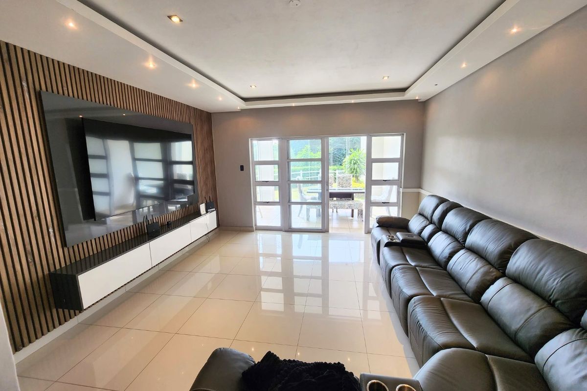 Modern living room featuring a stylish slatted timber feature wall, built-in media console, polished tile flooring, and direct access to an outdoor patio area.