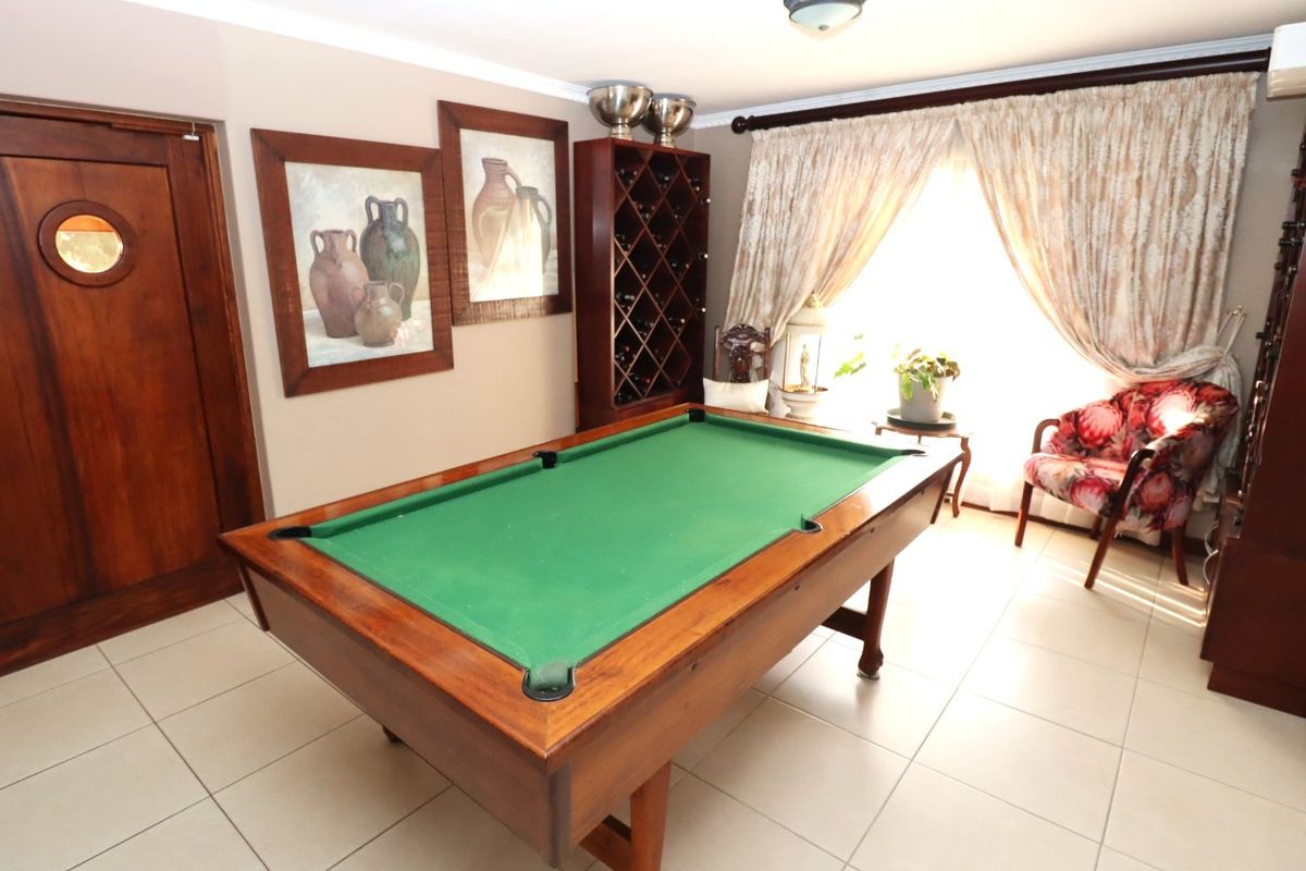 A living area featuring tiled flooring, a built-in wine rack, and a distinctive wooden door with a porthole window.
