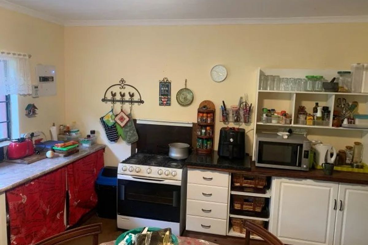 A functional kitchen area featuring a gas stove, built-in cabinetry, and open shelving, offering a practical layout for daily meal preparation.