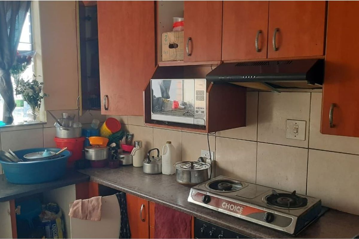 A functional kitchen featuring laminate cabinetry, a tiled backsplash, and a built-in gas hob with an extractor fan.
