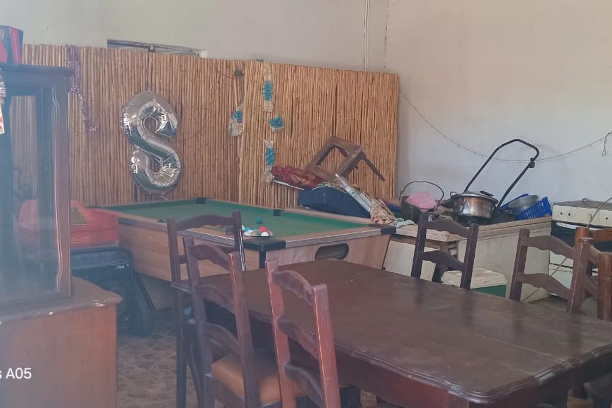 A multi-purpose living area featuring tiled flooring and basic electrical infrastructure, currently used as a casual dining and recreation space.
