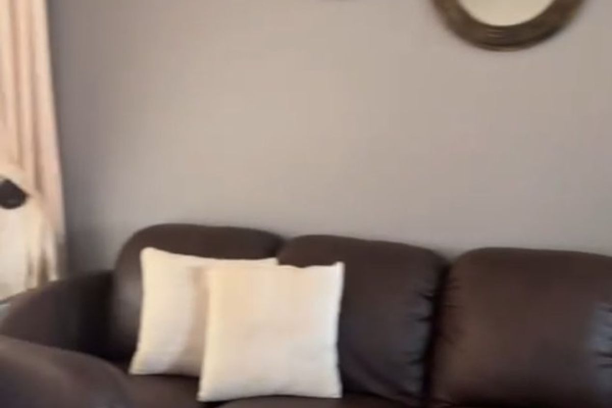 A view of a living room area featuring neutral wall paint and decorative wall mirrors.