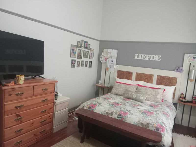 A bedroom featuring high ceilings with a decorative picture rail, providing a spacious feel with neutral wall tones.