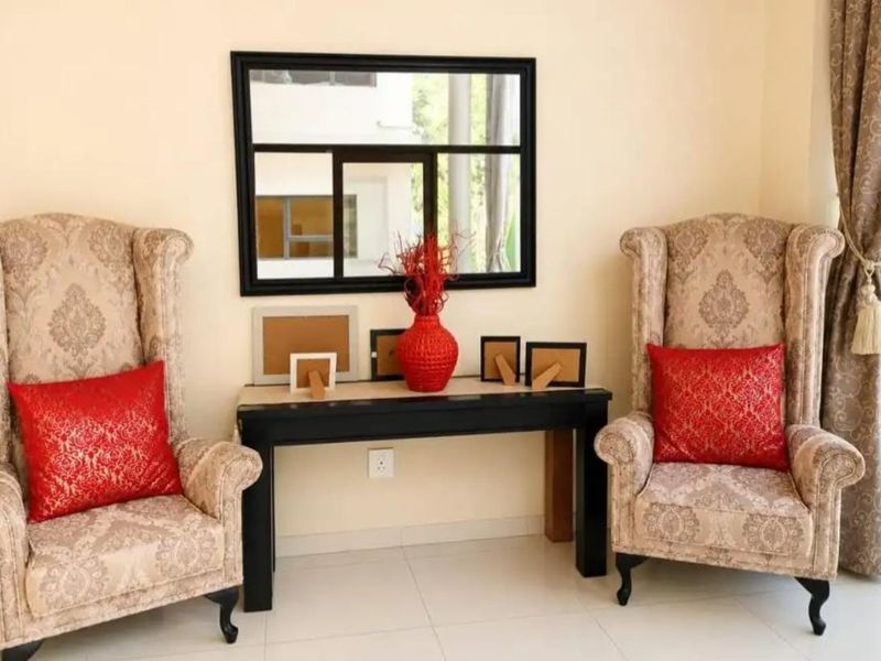 A living area featuring tiled flooring and a neutral wall finish, providing a simple and functional space.