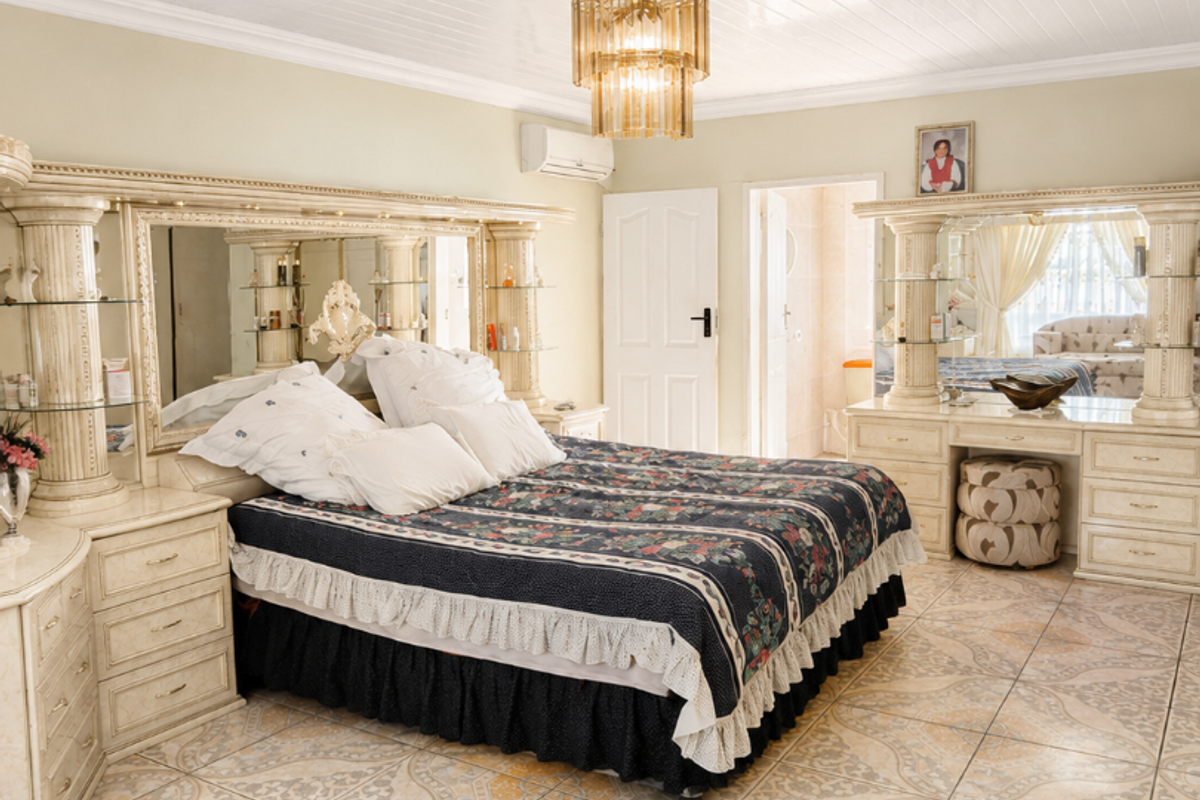Spacious bedroom featuring tiled flooring, a white tongue-and-groove ceiling, and a wall-mounted air conditioning unit.