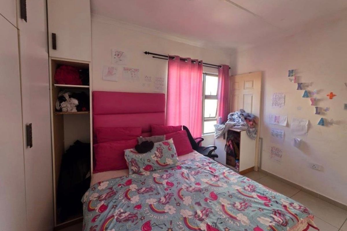 A functional bedroom featuring built-in cabinetry, tiled flooring, and a window with curtain rod installation.