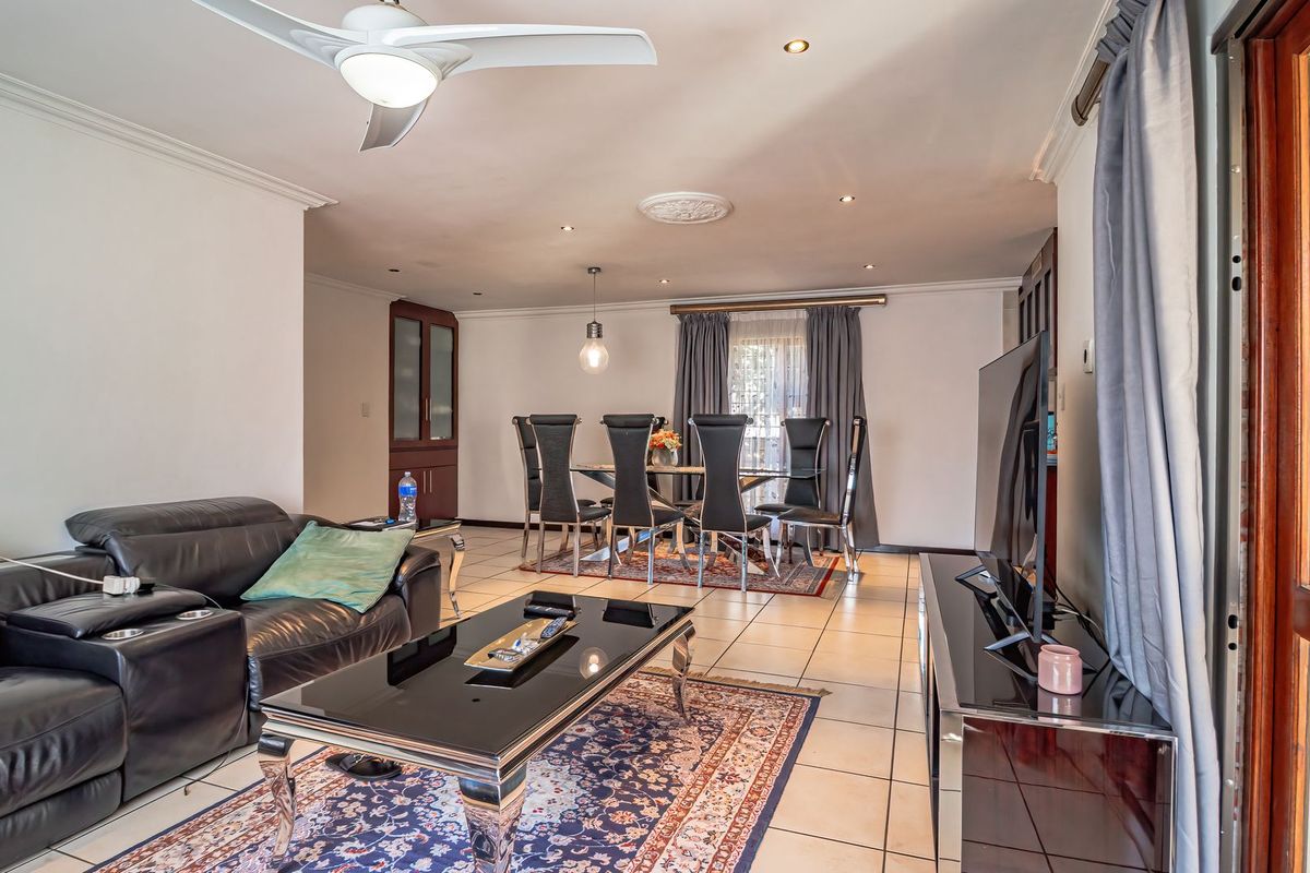 Open-plan living and dining area featuring tiled flooring, recessed ceiling lighting, a ceiling fan, and direct access to an outdoor space.