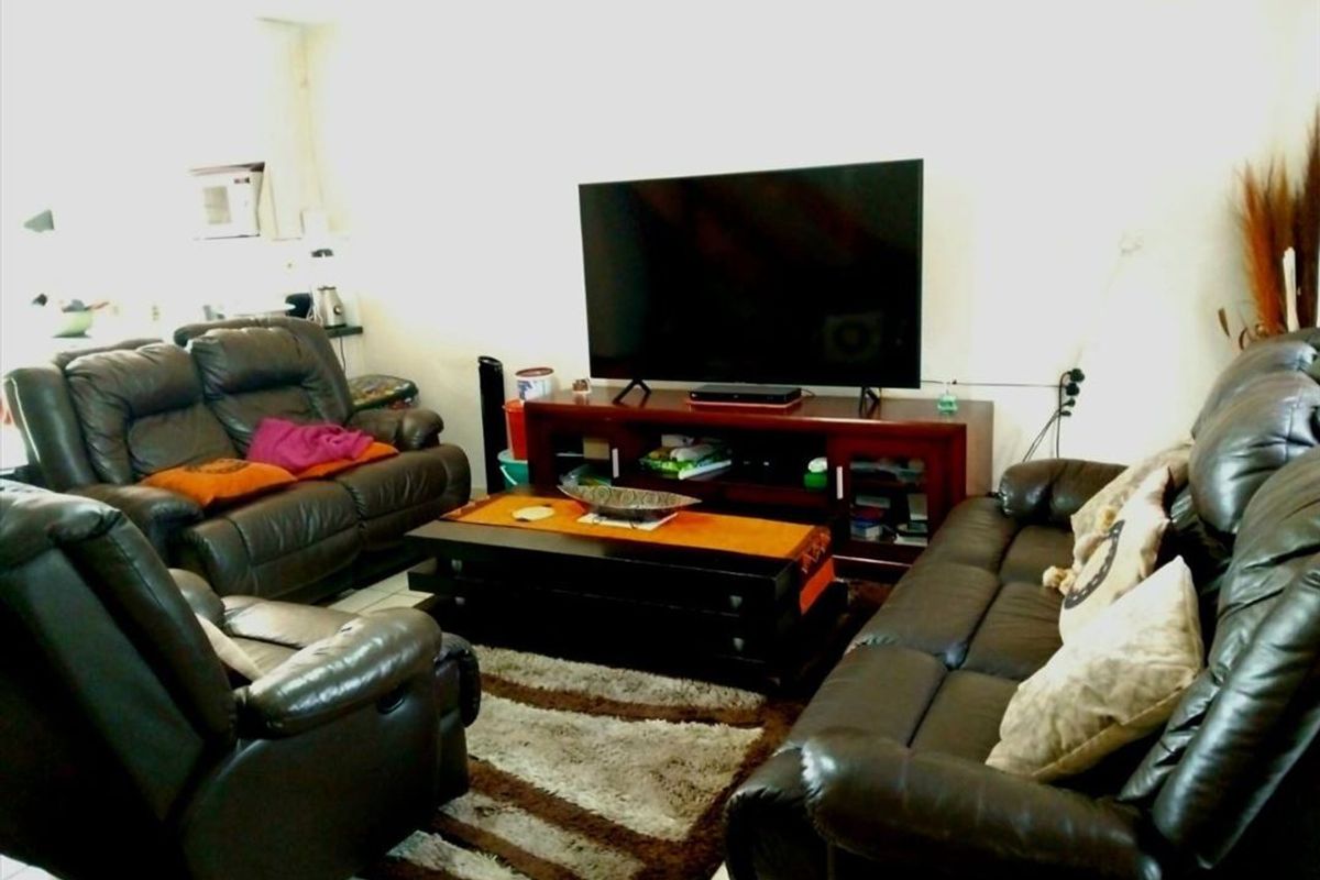 A comfortable living room area featuring tiled flooring and neutral wall finishes, providing a functional space for relaxation and entertainment.