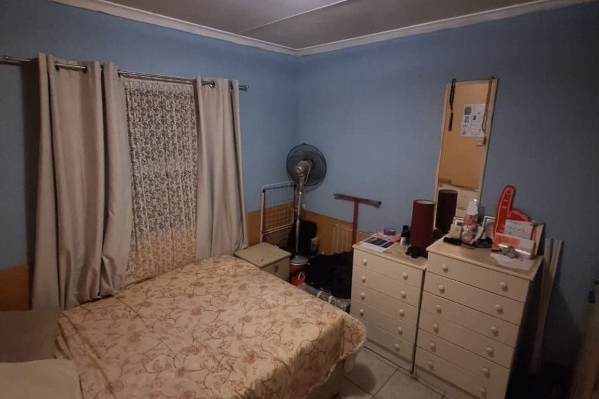 A bedroom featuring tiled flooring and a central ceiling light fixture, providing a functional space ready for cosmetic updates.