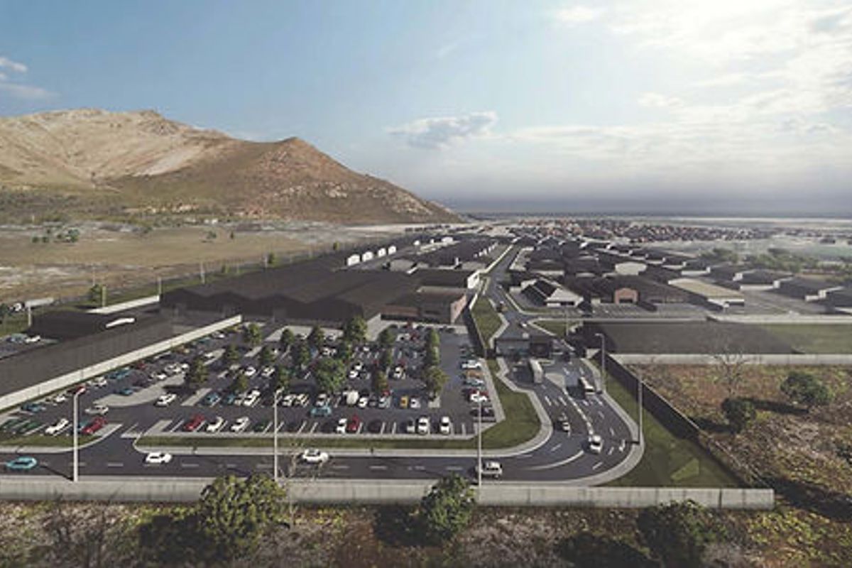 An aerial view of a proposed residential and commercial development site featuring planned infrastructure, road networks, and building layouts.