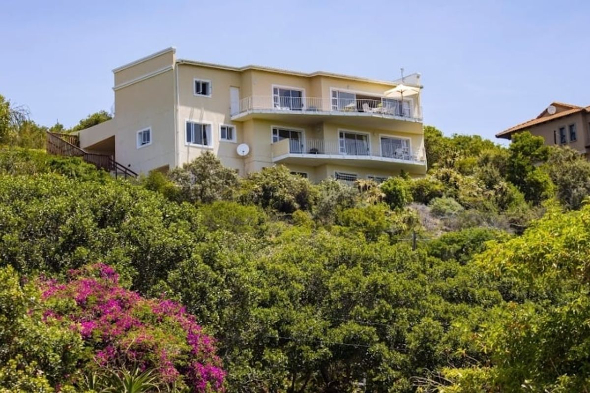 Elevated multi-story residential property featuring multiple balconies and extensive surrounding greenery, offering a private and scenic outlook.