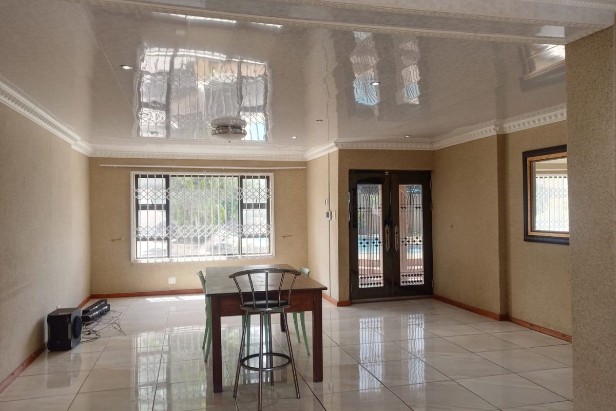 Spacious living area featuring high-gloss stretch ceilings, recessed lighting, and large ceramic floor tiles, offering a bright and open layout.