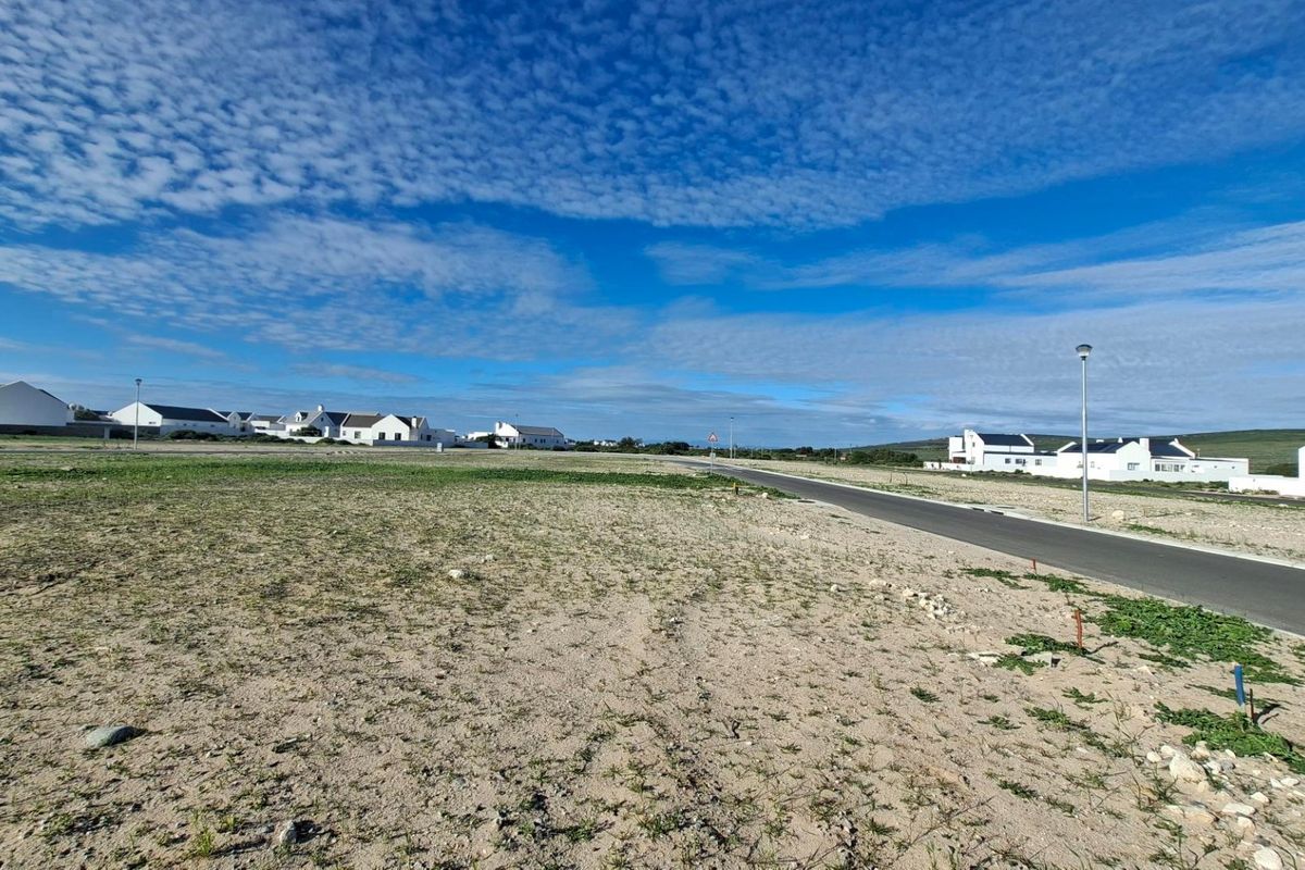 A vacant residential plot situated along a paved street with established neighborhood infrastructure and clear views of the surrounding area.