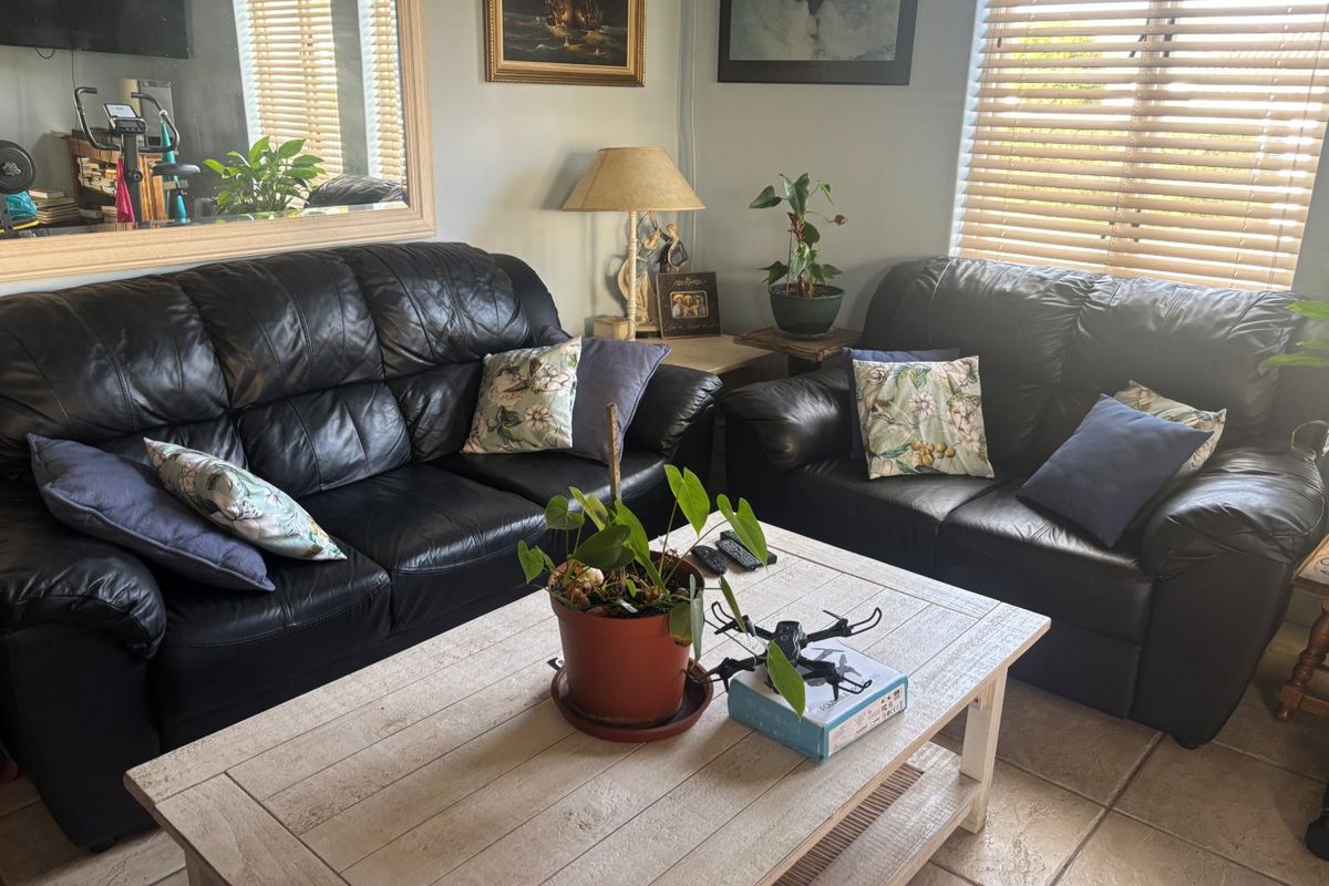 A comfortable living room area featuring tiled flooring and venetian blinds, providing a functional space for relaxation.
