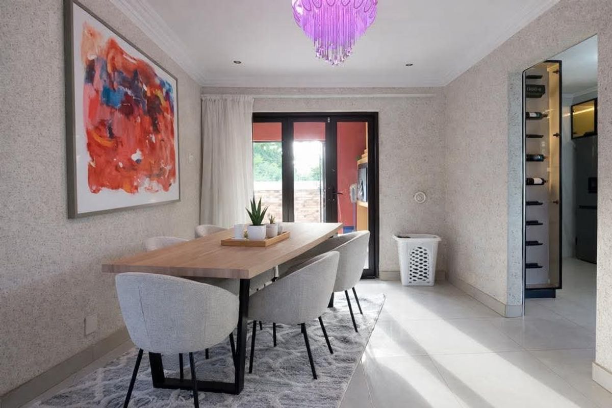 Modern dining room featuring tiled flooring, recessed lighting, a decorative chandelier, and a built-in wine storage unit with direct access to the patio.
