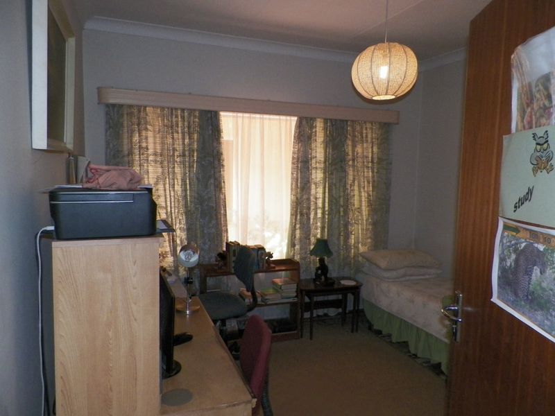 A functional bedroom featuring carpet flooring, cove cornicing, and a fitted curtain pelmet, offering a neutral base for potential updates.