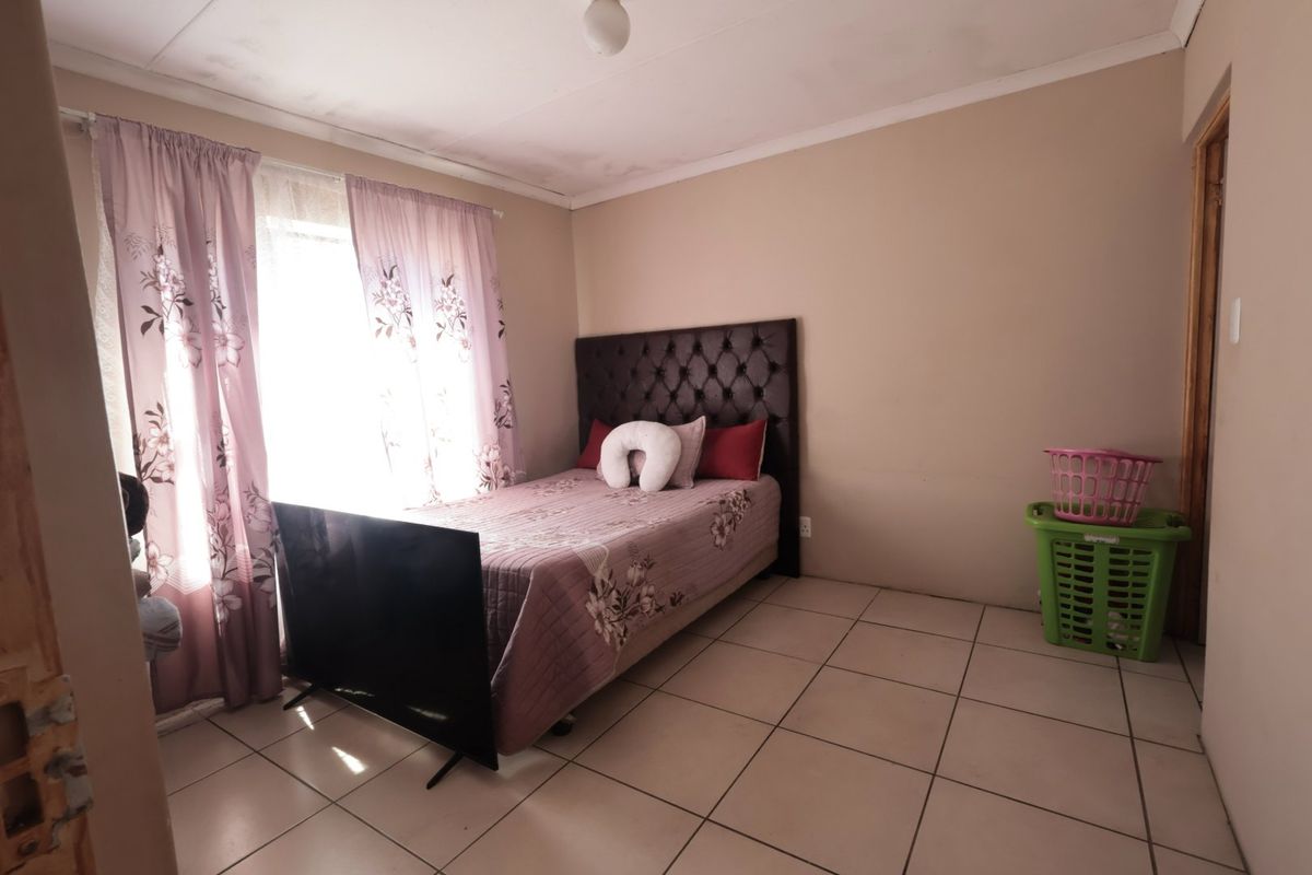 A bedroom featuring tiled flooring and coved ceilings, requiring some cosmetic attention to the ceiling and door frame.