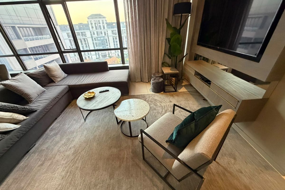Modern living room featuring floor-to-ceiling windows with urban views and a custom built-in media console.