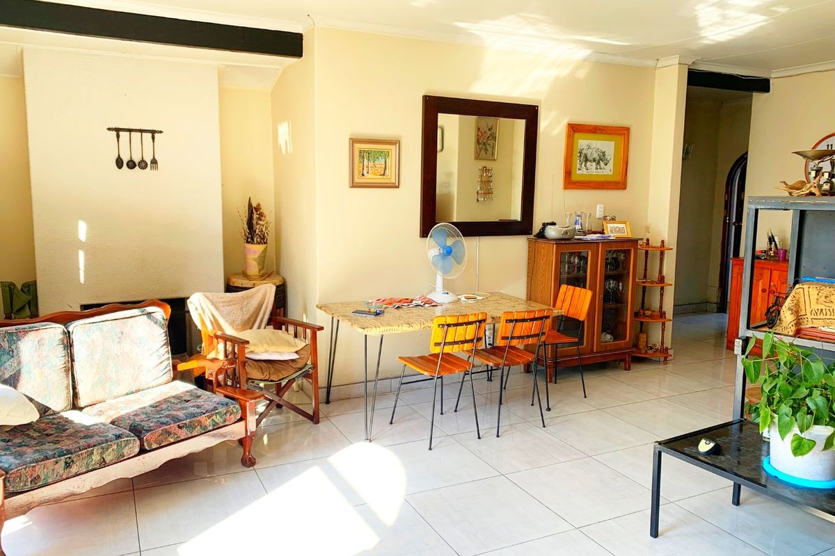 A bright living area featuring tiled flooring and a built-in fireplace, offering a functional space with natural light.