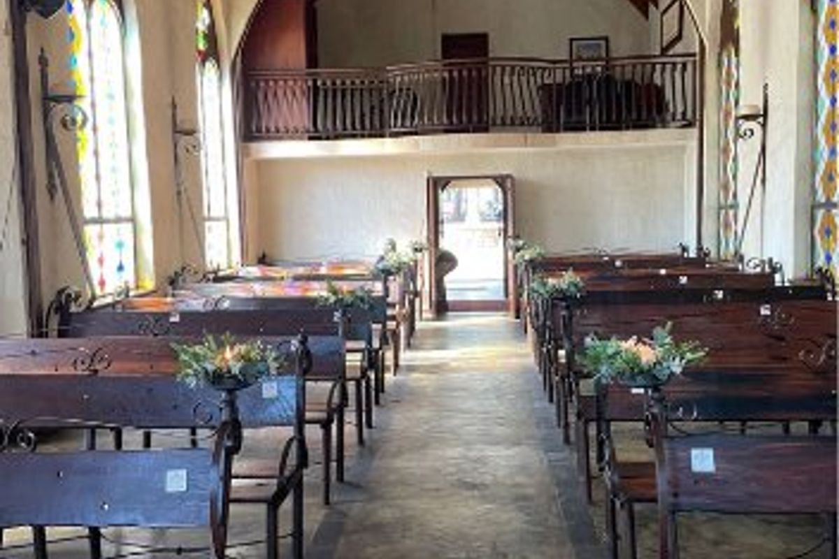 A beautifully maintained hall featuring a vaulted timber ceiling, stained glass windows, stone flooring, and a mezzanine level, ideal for events or gatherings.