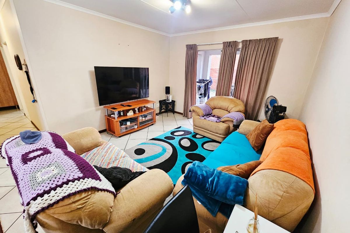 A living room featuring tiled flooring and a sliding glass door providing access to the exterior.