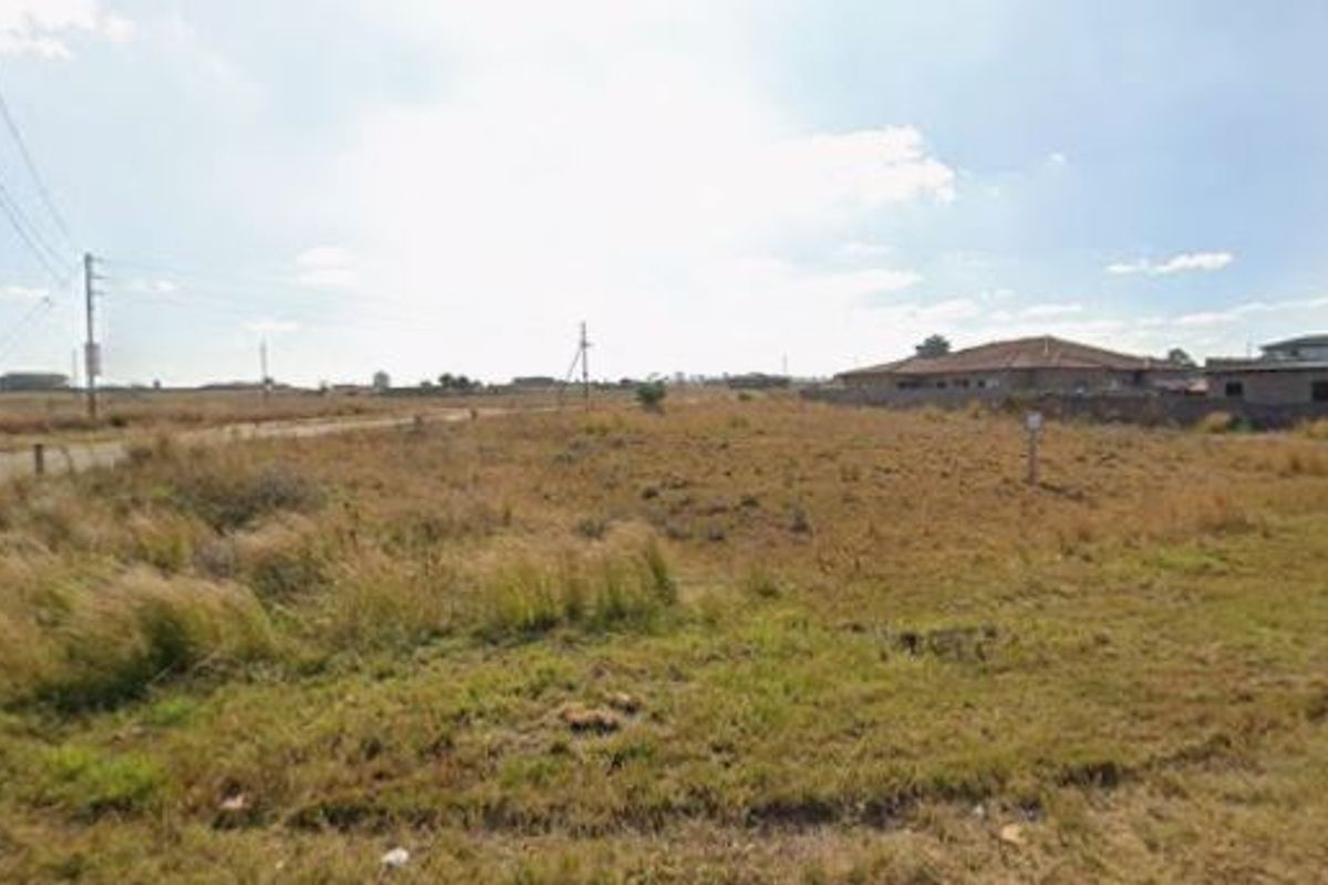 A vacant residential plot of land featuring natural grass cover and nearby utility infrastructure, suitable for future development.