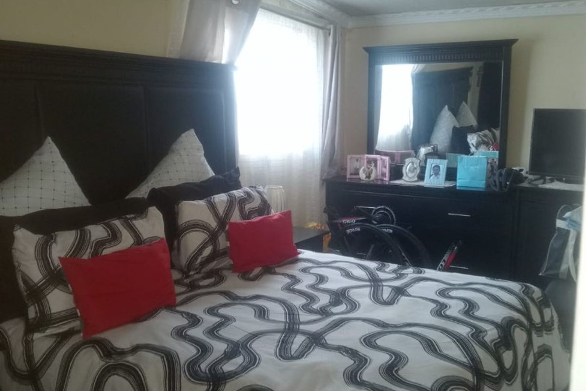 A bedroom featuring a ceiling with visible water staining and peeling paint, requiring maintenance and cosmetic updates to improve the overall condition.