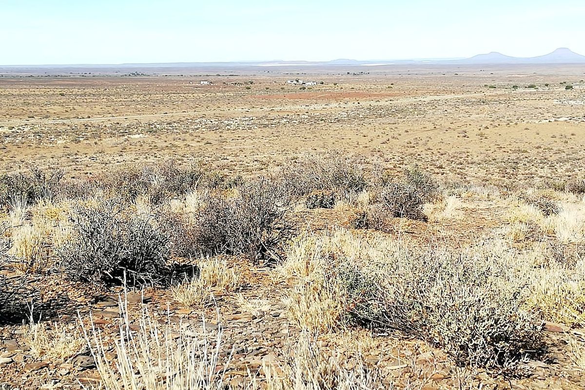 A wide-angle view of the expansive, arid landscape characteristic of the surrounding farm property.