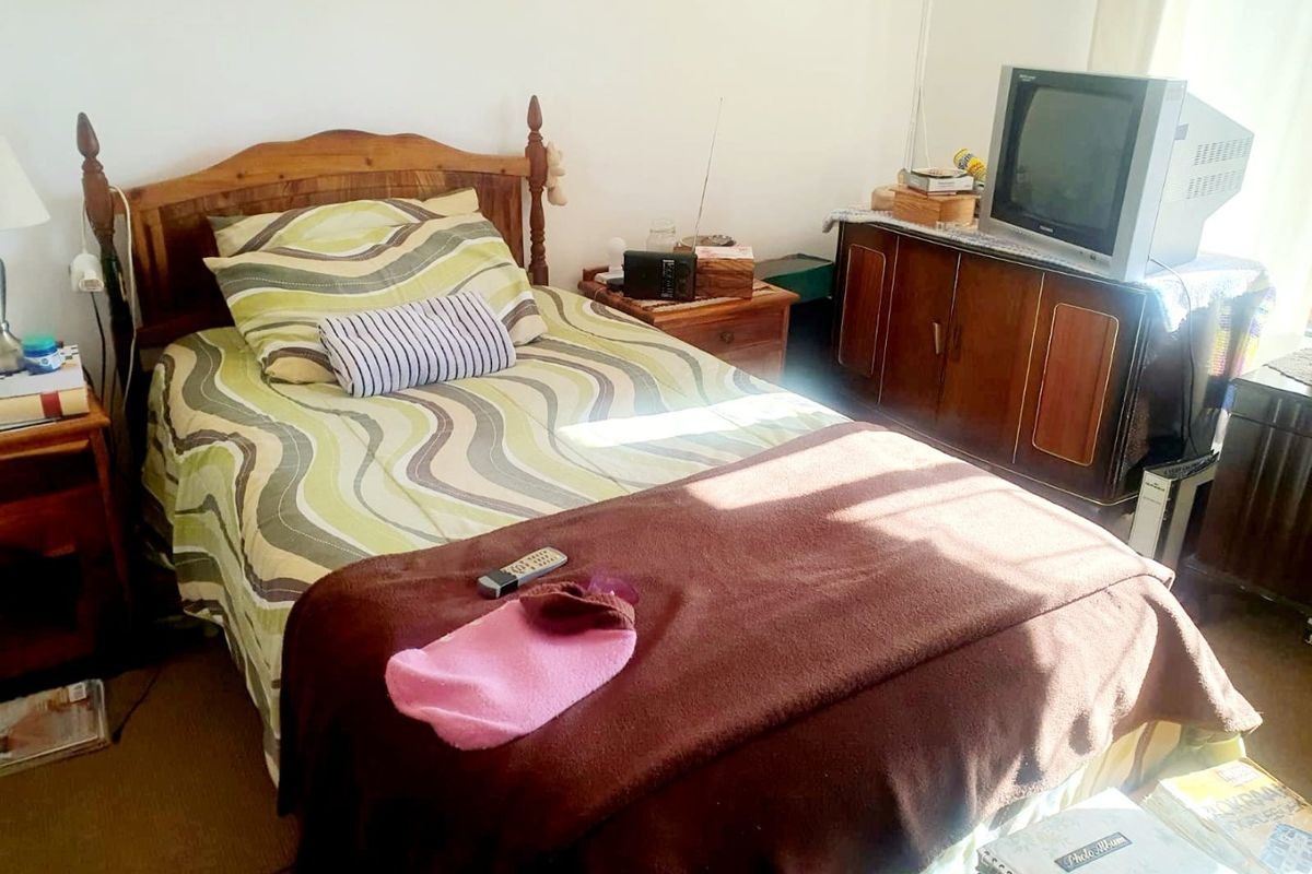 A standard bedroom featuring carpeted flooring and neutral wall finishes, providing a functional space for rest.