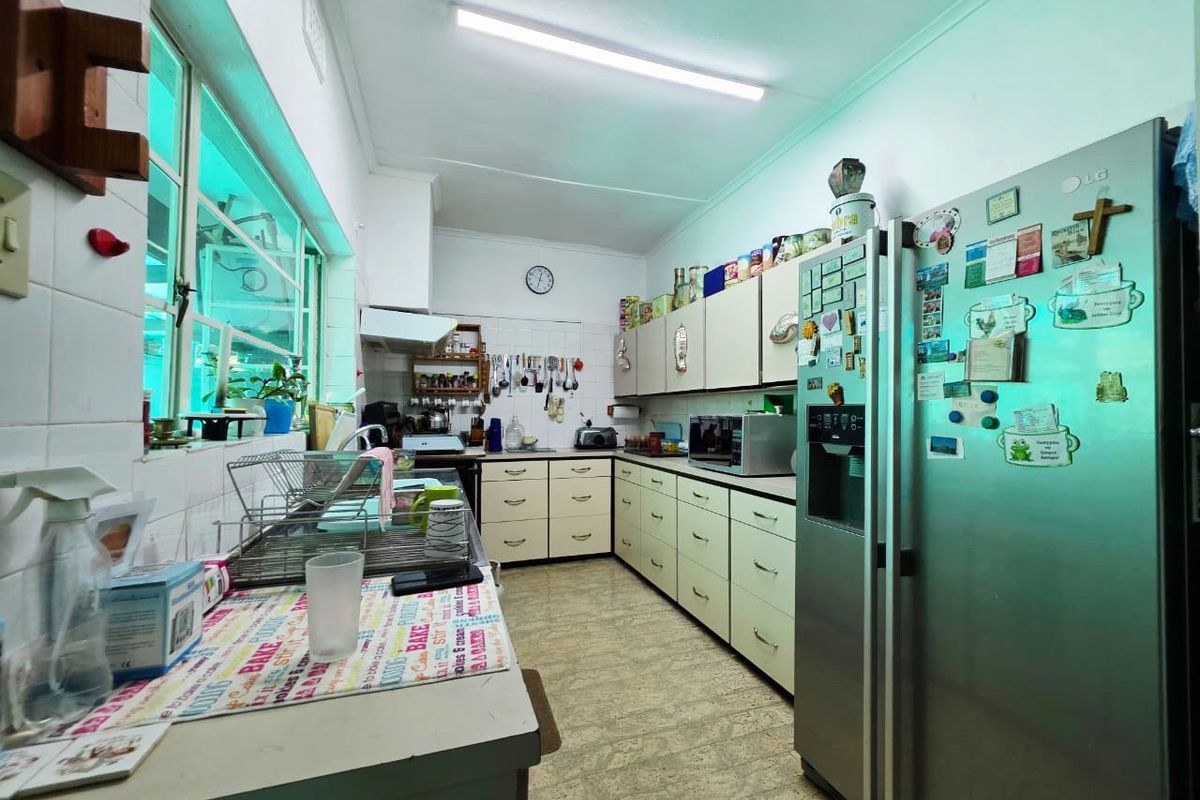 A functional kitchen featuring extensive built-in cabinetry, laminate countertops, a tiled backsplash, and an extractor fan, offering a practical workspace for daily meal preparation.