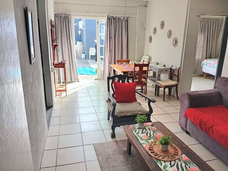 Open plan living area featuring ceramic floor tiles and direct access to an outdoor patio through a glass panel door.