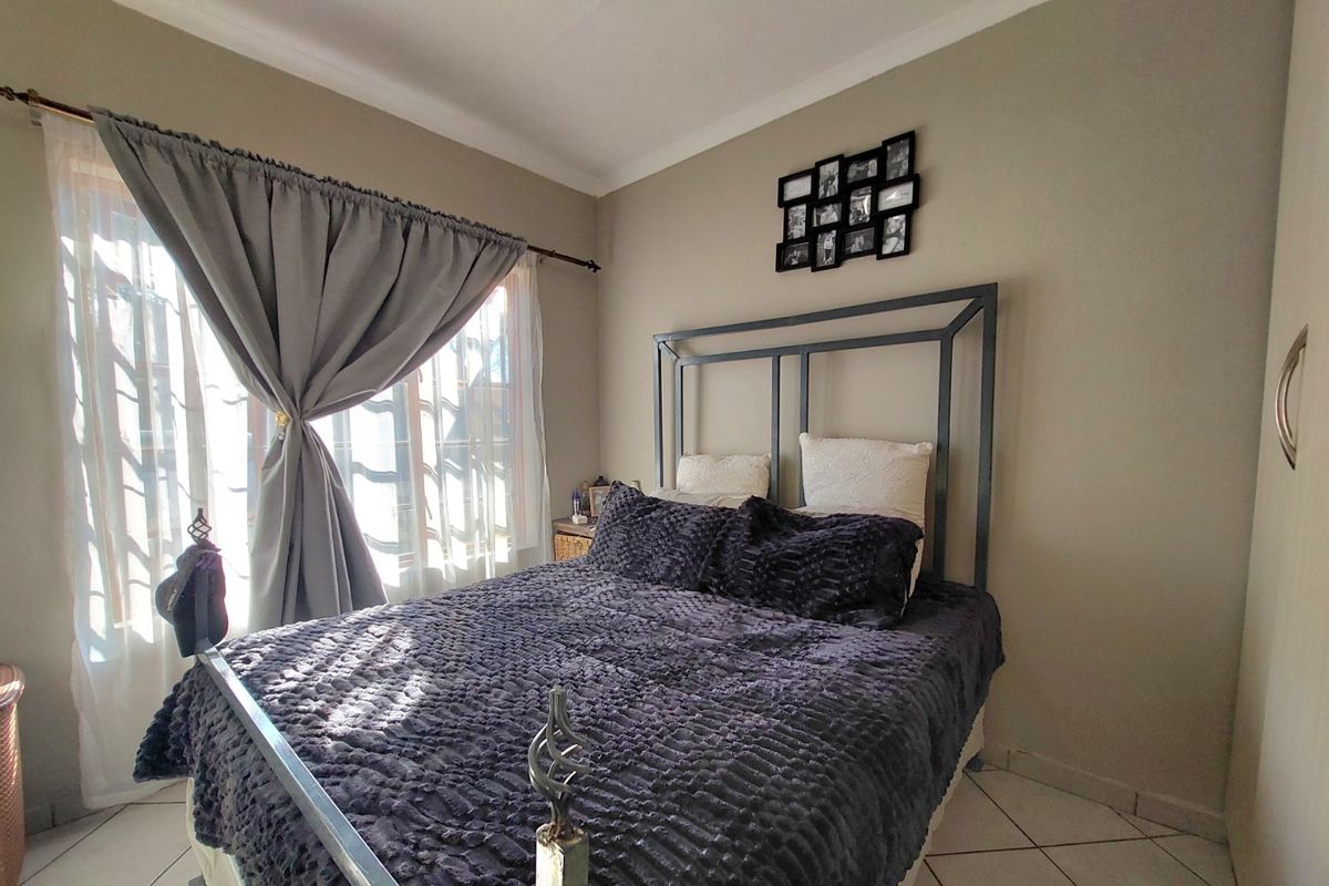 A functional bedroom featuring tiled flooring and coved ceiling details, providing a neutral base for personalization.