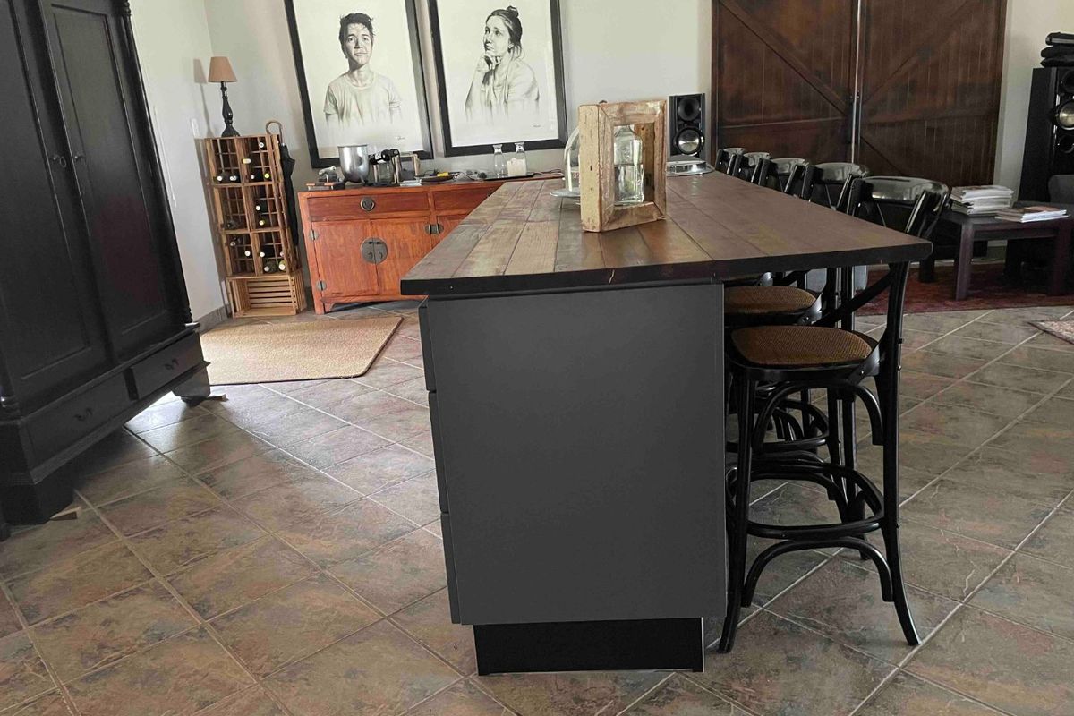 A kitchen area featuring a large central island with a dark finish and a wooden countertop, complemented by rustic sliding barn doors.