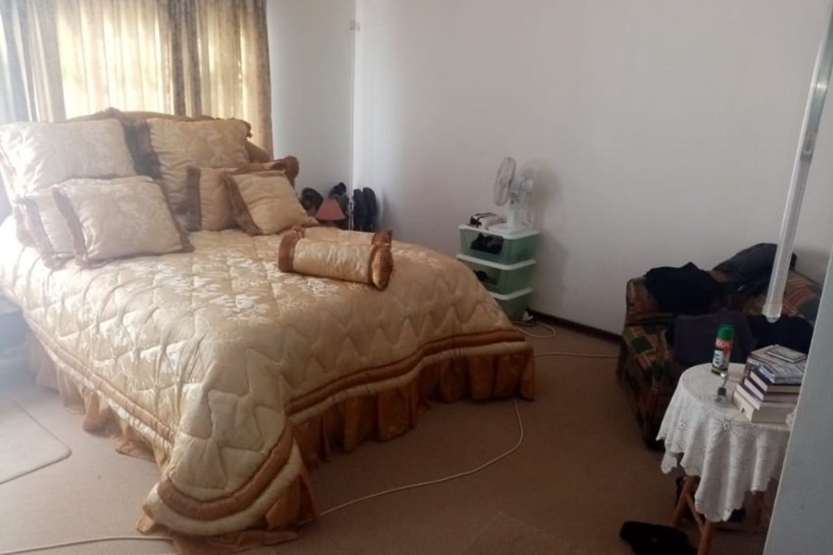 A standard bedroom featuring carpeted flooring and window treatments, offering a functional space ready for personalization.