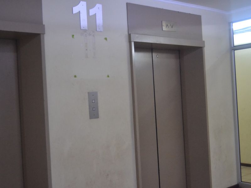 A view of the apartment building hallway featuring elevator access and floor level signage.