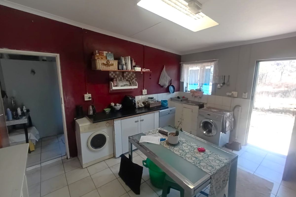 A functional kitchen area featuring tiled flooring, built-in cabinetry, and direct access to an outdoor space, offering potential for modernization and aesthetic updates.