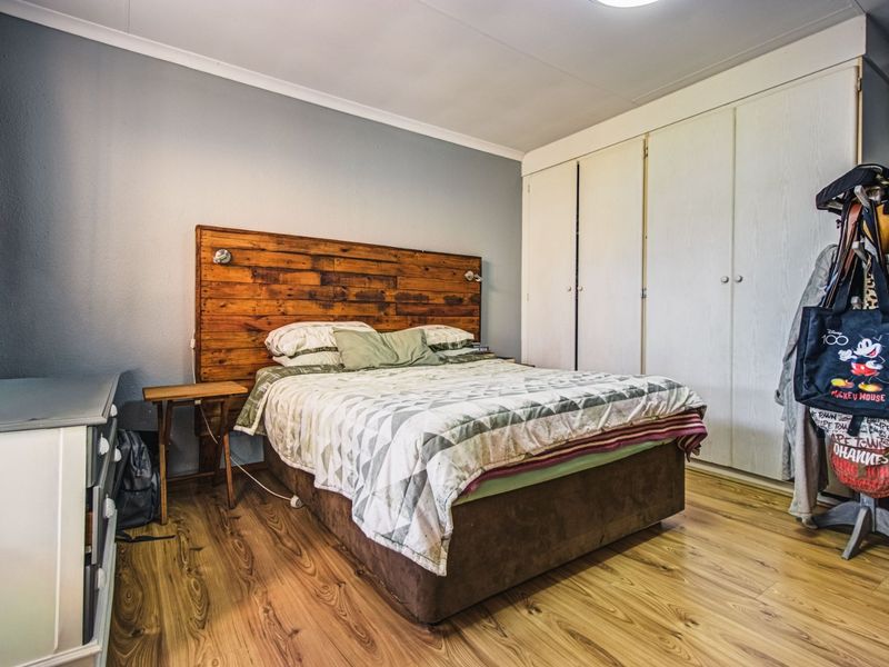 A bedroom featuring laminate flooring and built-in cupboards, providing functional storage space.