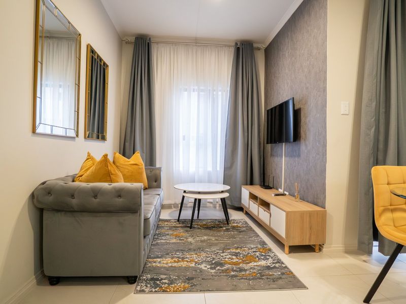 A well-maintained living room featuring tiled flooring, a textured accent wall, and neutral decor, creating a comfortable and inviting space.
