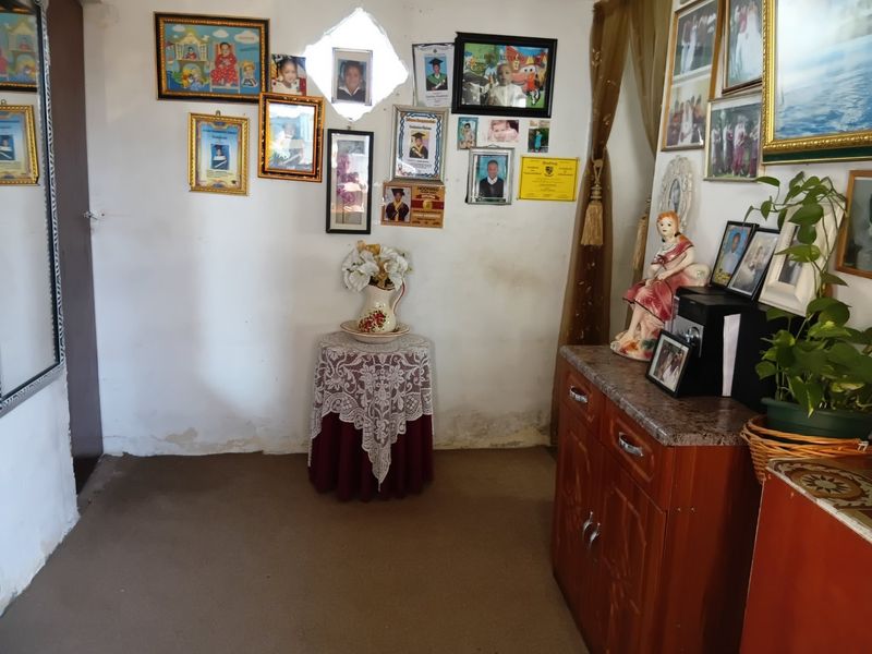 A living area showing signs of wall deterioration and dampness, requiring maintenance and cosmetic updates to improve the interior finish.