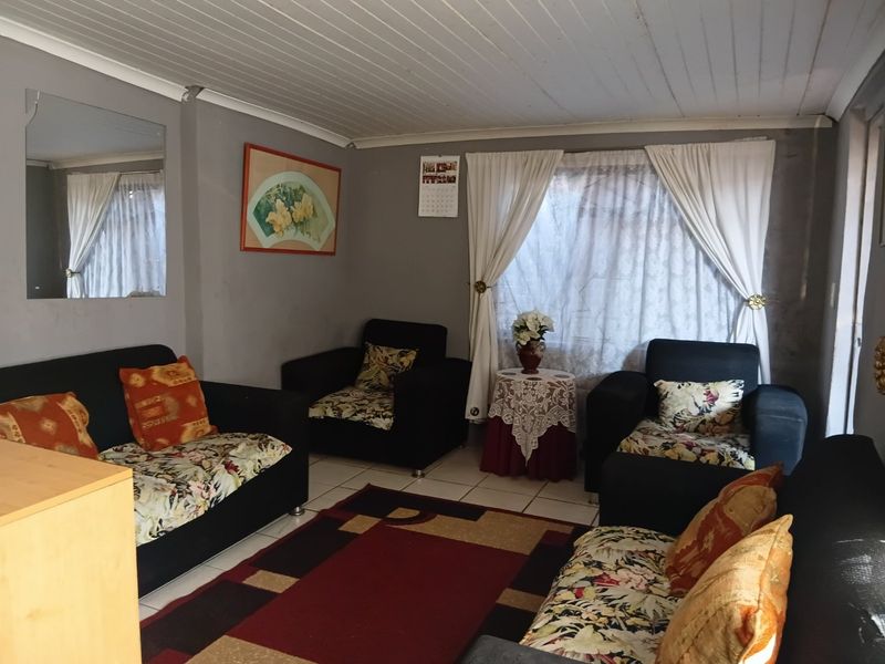 A living room featuring tiled flooring and a tongue and groove ceiling, requiring cosmetic updates to improve the overall aesthetic and finish.