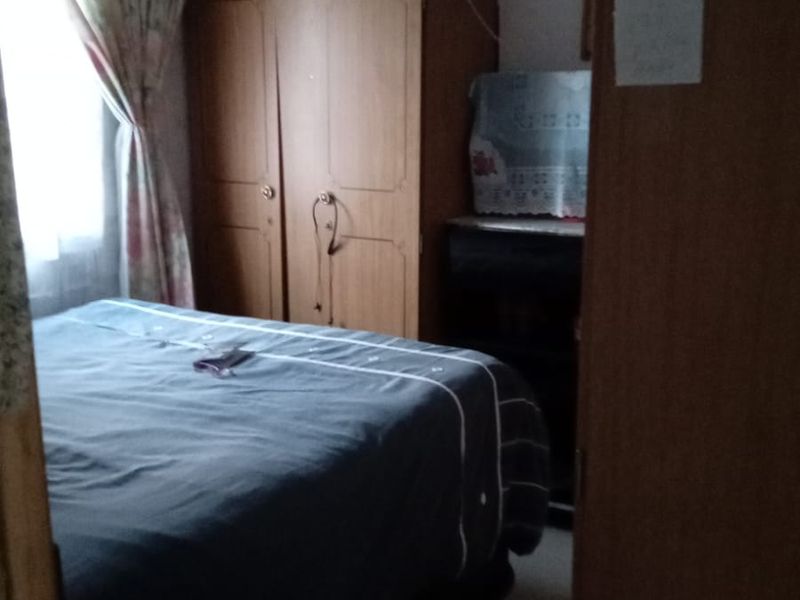 A bedroom featuring a built-in wardrobe and natural light from the window.