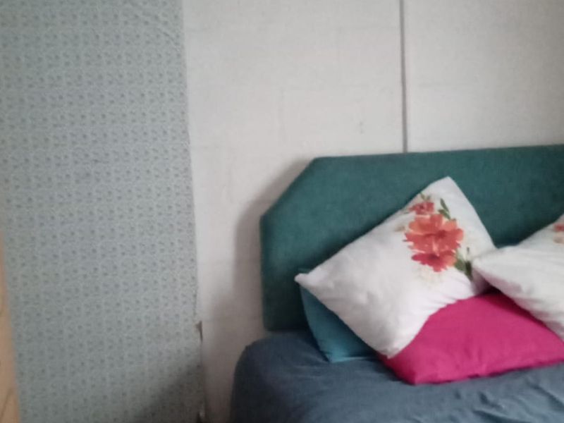 A bedroom featuring exposed blockwork walls and a sliding door track, requiring cosmetic finishing to improve the overall aesthetic and condition.
