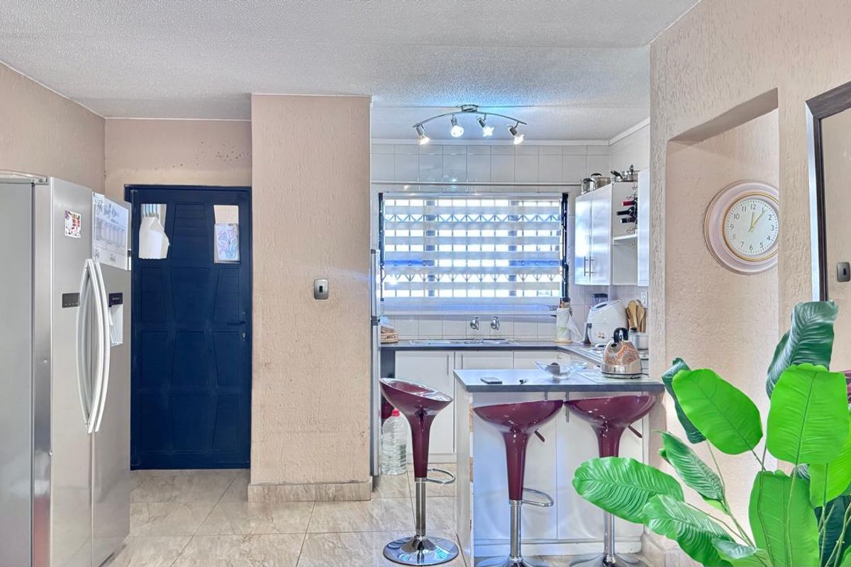 A functional kitchen featuring built-in cabinetry, a breakfast bar, and tiled flooring, offering a practical layout for daily meal preparation.