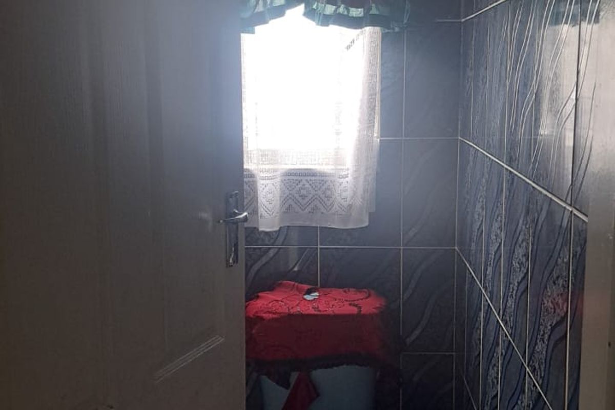 A small bathroom featuring full-height wall tiling and a standard toilet suite.