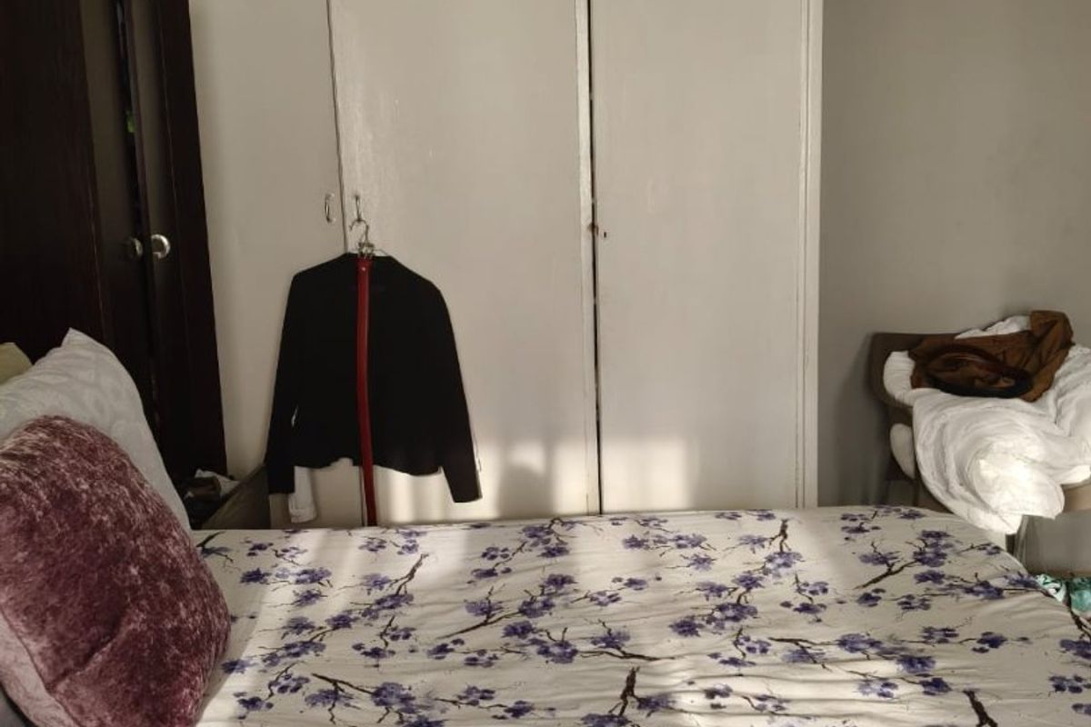 A bedroom featuring built-in cupboards with white doors, providing functional storage space within the room.