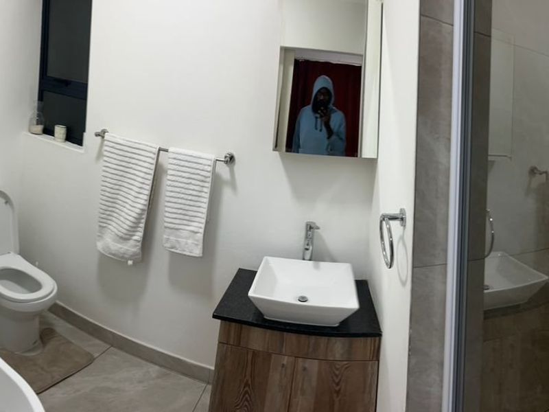 Modern bathroom featuring a freestanding bathtub, vessel sink vanity, and a separate shower enclosure with neutral tile finishes.