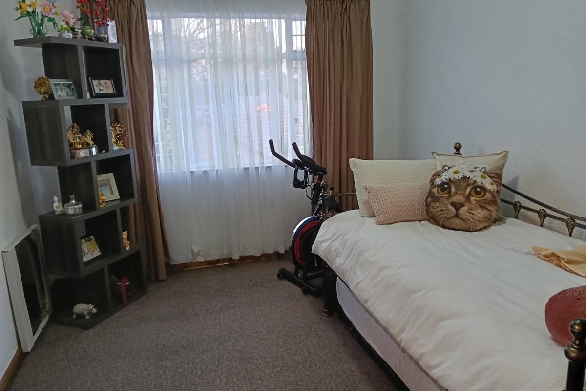 A standard bedroom featuring carpeted flooring and window treatments, offering a functional space for rest or multi-purpose use.