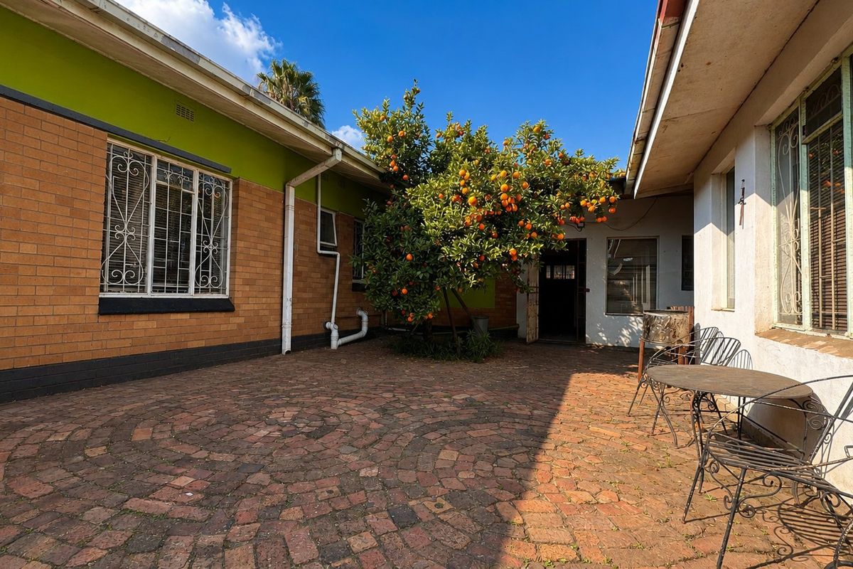 A private rear courtyard featuring brick paving and established citrus tree, providing a quiet outdoor space for relaxation.