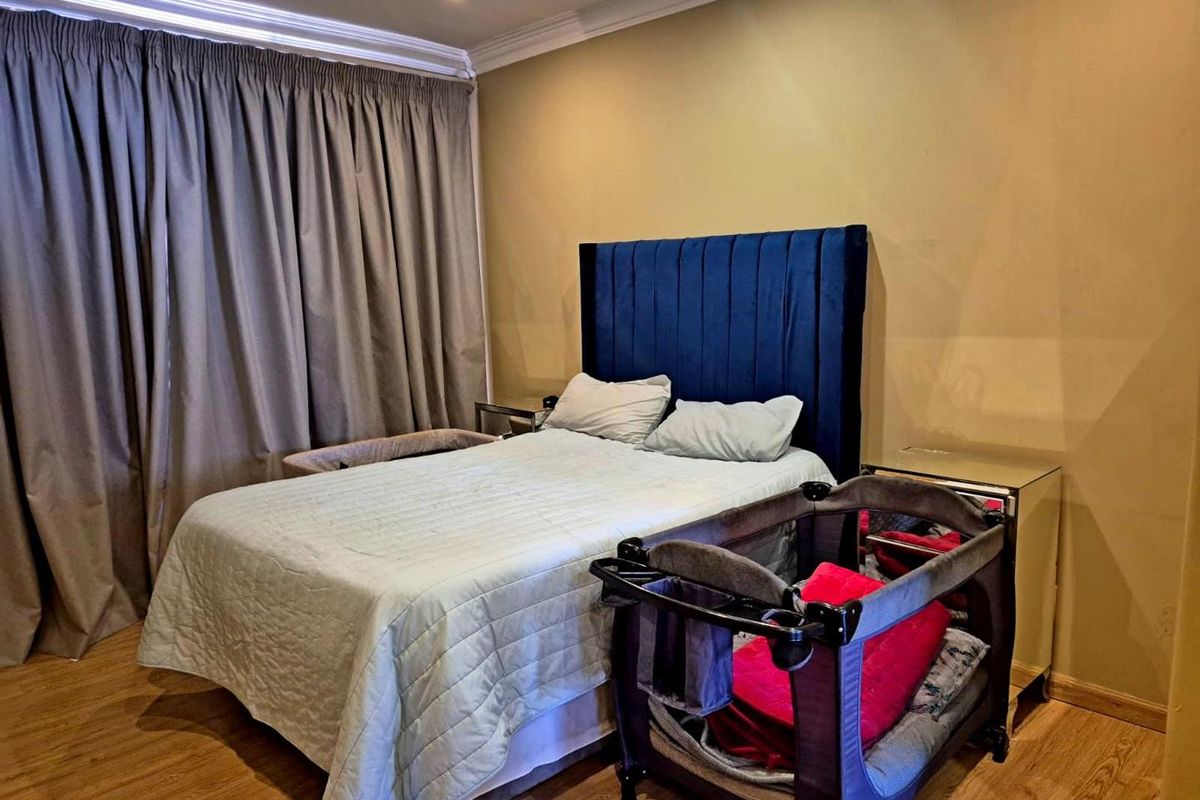 A bedroom featuring laminate flooring, recessed downlighting, and decorative coving.