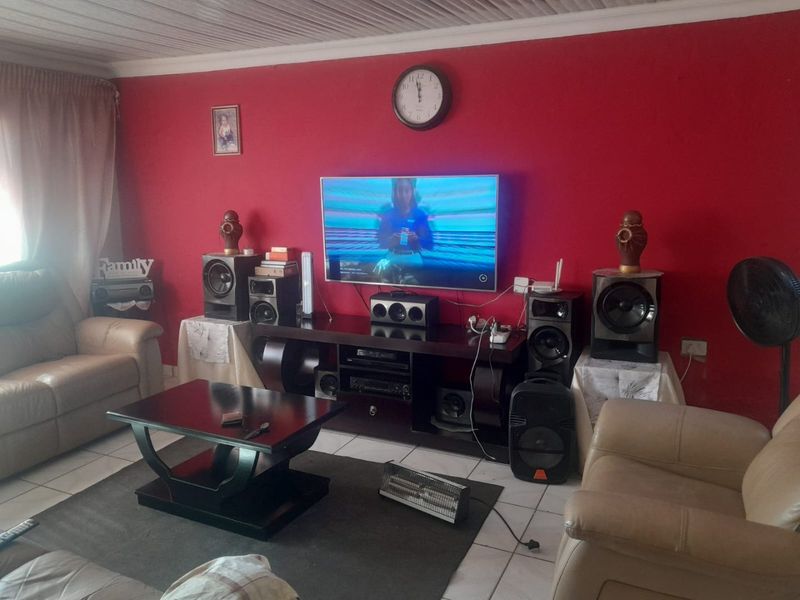 A living room featuring tiled flooring and a coved ceiling, currently finished with bold red wall paint.